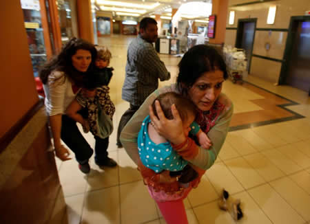 Mulheres com crianças ao colo fogem em busca de segurança, enquanto a polícia dispara sobre homens armados que abriram fogo num centro comercial em Nairobi, no Quénia. Créditos: Reuters / Goran Tomasevic Mulheres com crianças ao colo fogem em busca de segurança, enquanto a polícia dispara sobre homens armados que abriram fogo num centro comercial em Nairobi, no Quénia. Créditos: Reuters / Goran Tomasevic