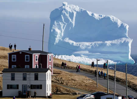 Locais assistem à passagem do primeiro iceberg da época, num local que é conhecido por “beco dos icebergs”, perto de Ferryland, no Canadá. Locais assistem à passagem do primeiro iceberg da época, num local que é conhecido por “beco dos icebergs”, perto de Ferryland, no Canadá.