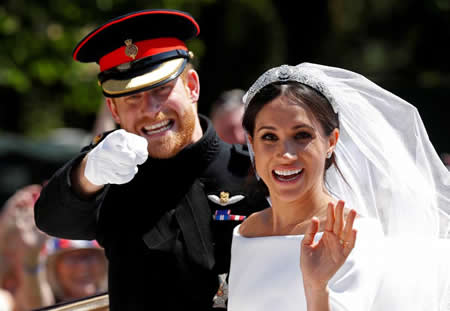 O príncipe Harry, da Grã-Bretanha, gesticula ao lado da sua esposa Meghan, enquanto andam de carruagem após a cerimónia de casamento na capela de São Jorge, em Windsor, na Inglaterra. Créditos: Reuters / Damir Sagolj O príncipe Harry, da Grã-Bretanha, gesticula ao lado da sua esposa Meghan, enquanto andam de carruagem após a cerimónia de casamento na capela de São Jorge, em Windsor, na Inglaterra. Créditos: Reuters / Damir Sagolj