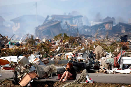 Uma mulher chora, sentada na estrada, depois de um terramoto e tsunami terem destruído a cidade de Natori, no distrito de Miyagi (norte do Japão). Uma mulher chora, sentada na estrada, depois de um terramoto e tsunami terem destruído a cidade de Natori, no distrito de Miyagi (norte do Japão).