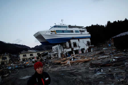 Um sismo de magnitude 9.0 seguido de tsunami em Otsuchi, Japão, deixou um barco no cima de um edifício completamente destruído.  Um sismo de magnitude 9.0 seguido de tsunami em Otsuchi, Japão, deixou um barco no cima de um edifício completamente destruído.