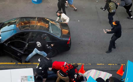 Um homem sai de um veículo com uma arma quando Dan Gregory está a ser atendido por médicos, depois de ser alvejado no braço por um condutor, o qual tentava atravessar um protesto contra a desigualdade racial no rescaldo da morte de George Floyd