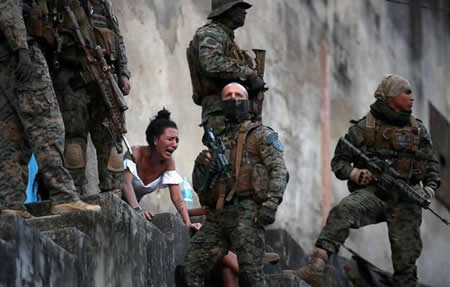 Juliana, que diz estar grávida de quatro meses, reage em frente do corpo do marido Davi Barboza, que foi alvejado em Sao Carlos durante uma operação policial após fortes confrontos entre gangues de droga, no Rio de Janeiro, Brasil. "Eu quero pedir a quem quer que seja que esteja nessa vida para sair", disse Juliana. "Pensem na vossa família porque é muito difícil para nós. Não sei como vou voltar para casa sem o voltar a ver". 