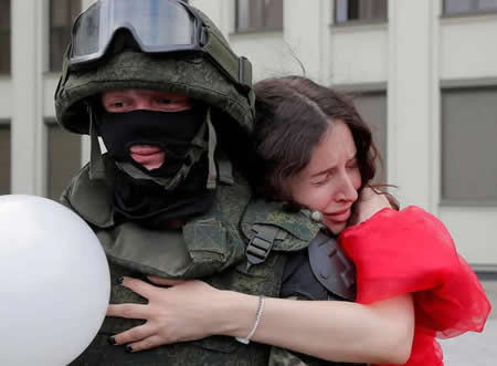 Um manifestante abraça um elemento das tropas do Ministério do Interior da Biolorrússia, que está de guarda durante uma manifestação da oposição contra a violência policial e os resultados das eleições presidenciais, perto da casa do Governo, na Praça da Independência, em Minsk.