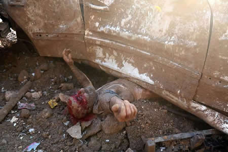 Um homem é retirado debaixo de um carro depois da explosão no porto de Beirute, no Líbano.