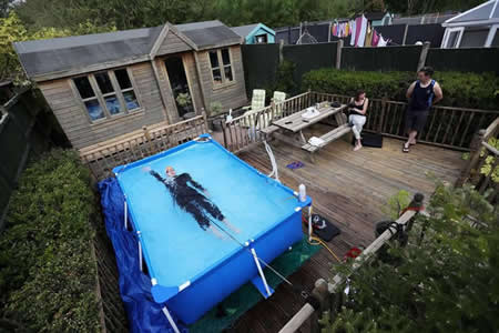 O triatleta Lloyd Bebbington treina numa piscina no jardim de casa, em Newcastle-under-Lyme, Reino Unido. 