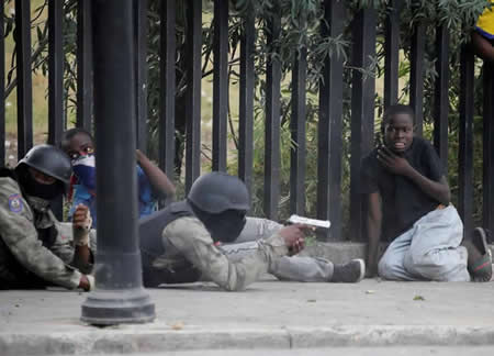 Um rapaz imita os gestos dos homens da Polícia Nacional do Haiti durante o tiroteio ocorrido em Champ de Mars, Porto Príncipe, simulando apontar uma arma.
